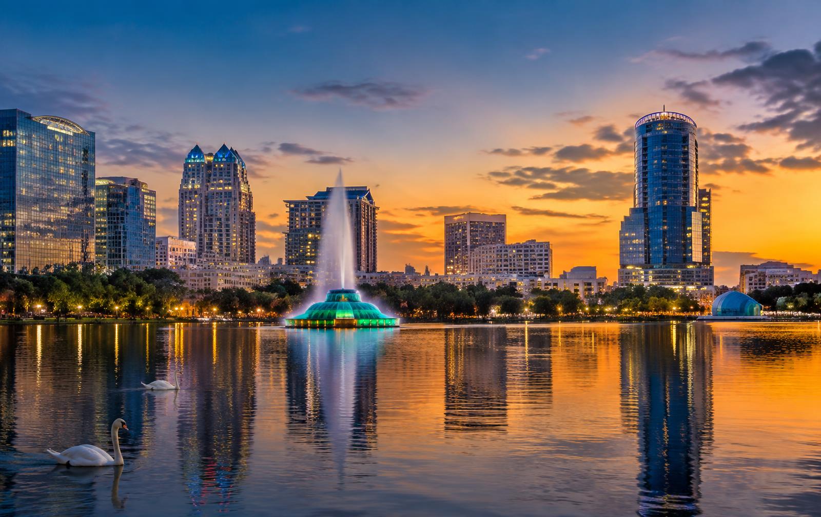 Lake Eola fountain and the Downtown Orlando skyline reflected across the water at dusk